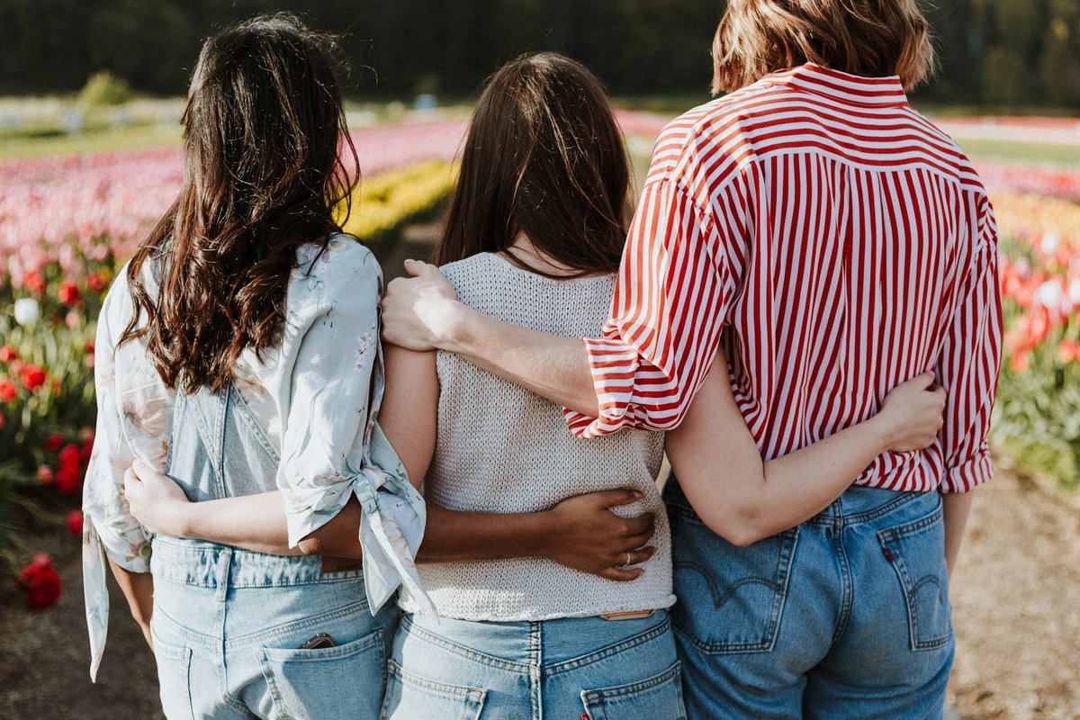 Tres personas tomadas de la mano, símbolo de los vínculos y la comunidad frente a la soledad